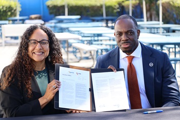 Secretary Omishakin and HHS Agency Secretary Johnson holding up the signed Policy on Road Safety